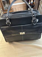 Front view of the Samsonite black executive rolling briefcase showing handles, front pocket and closure