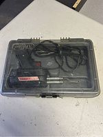 Closed plastic case with Weller soldering iron and power cord visible inside.