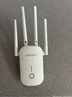 Front view of Joowin WiFi extender showing four antennas, LED lights, and power button.
