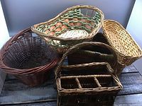 Photo showing all five baskets in a group on a wooden floor, highlighting their varied sizes and designs.