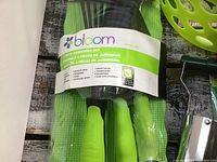 Photo showing the Bloom brand 4-piece gardening set in green and black handle packaging, clearly new and sealed.