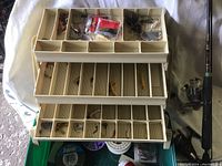 Open beige Plano 3 tray tackle box showing fishing lures and tackle organized in multiple compartments