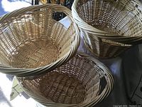 Photo showing three new oval wicker baskets stacked, displaying their size and shape.