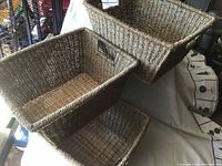 Three new rectangular woven baskets stacked showing natural fiber texture and hand holes on sides.