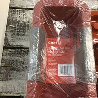 Three red silicone loaf pans shrink-wrapped with label showing brand Chef, silicone loaf pan, dishwasher safe