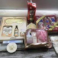 Photo showing multiple spa and skincare gift sets laid out including face masks, body scrubs, lotions, and accessories.