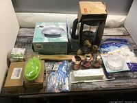 Photo of entire lot showing coffee maker, nail dryer box, bamboo scrubber, green silicone scrubber, nail polishes, pill organizer, cotton pads and other spa related items