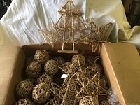 Box showing woven vine decorations of balls, stars, and tree shapes