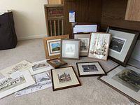 Various framed and unframed architectural and landscape art prints and originals by Dennis Park laid on carpeted floor.