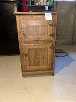 Full view of Kenmore mini fridge designed to look like a wooden ice box with wood grain exterior and brass hardware.
