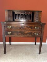 Front view of desk showing two large bottom drawers, brass oval pulls, fold-down writing surface and hutch above