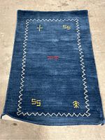 Front view of blue Safavieh Himalaya rug with embroidered accents and zigzag border pattern.