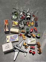 Photo showing full lot of fast food and tin toys including glass mugs, miniature vehicles, planes, and wrapped Happy Meal toys from McDonald's and Burger King.