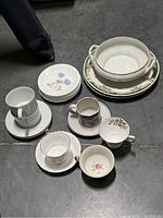 Top-down view of assorted china pieces including cups, plates, and a serving bowl.