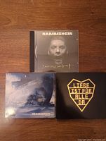 Top view of three Rammstein CD cases showing album cover art for "Rosenrot," "Reise, Reise," and the slip cover for "Liebe ist für alle da."