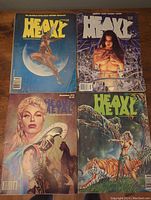 Four Heavy Metal magazines with illustrated fantasy covers showing various characters and scenes; magazine titles and some dates visible