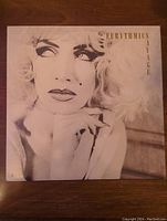 Front cover of Eurythmics Savage vinyl album showing stylized portrait of a woman with platinum blonde hair and makeup.