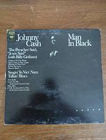 Front cover of the Johnny Cash Man In Black vinyl record album showing artist name, album title, and shadow image of Johnny Cash on black background.