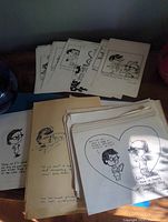 Stacks of original hand-drawn comic strips on white paper by Ottawa artist Davy, showing multiple strips with cartoon characters and handwritten text.