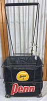 Full view of vintage Penn tennis ball carrier showing wire metal frame and black fabric bag with Penn logos.