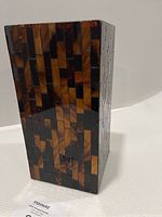 Side view of the rectangular mosaic hurricane candle holder showing amber and brown glass tiles in a brick pattern