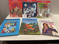 Front view of six hardcover children's books arranged in two rows, including Fisher-Price Little People Big Books and others