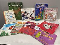 Nine children's books laid out showcasing front covers, including The World of Baby Animals, The Football That Won, The Bernstein Bears' The Christmas Tree, and Winnie The Pooh and Some Bees, among others.