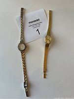 Photo of two ladies cocktail watches laid flat on white background with auction paper