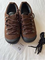 Top view of brown Keen hiking shoes with laces and extra pair of laces visible