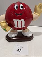 Front view of red M&M candy dispenser figure with price card in front