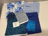 Full view of all assorted blue tone quilting fabrics arranged flat.