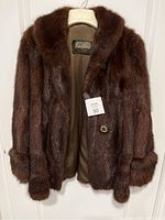 Front view of waist length brown mink coat showing two-button closure, fur texture, collar and cuffs.