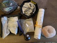 Photo showing Zen garden wooden frame, glass dishes, sand in bags, pink salt tea light holder, hand-painted wooden knarr model boat