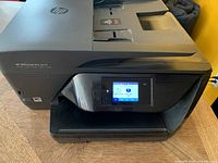 Front and side view of HP OfficeJet Pro 6978 showing model number, touchscreen display, and paper input/output areas.
