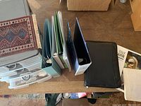 Overall lot contents showing plastic organizer, binders, leather folio