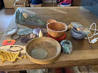Overview of assorted decorative items on table including pottery, crystals, baskets, and candles