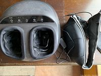 Top view of Renpho electric foot massager showing control buttons and padded foot slots with device cables visible, alongside black padded belt-style back massager also plugged in.