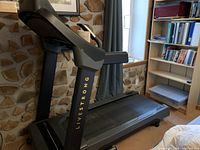 Side view of Livestrong treadmill showing the deck and frame with Livestrong branding in yellow.