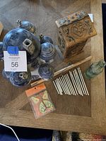 Top view of pottery diffuser set, carved wooden box, wind chimes, blue-green stone discs, small glass bottle, and packaged butterfly sticker pack
