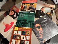 Photo showing six assorted vinyl record albums with classical, operatic, and musical themes.