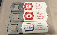 Close-up of three vintage Molson and Molson Canadian branded flat bottle openers with white handles and red and blue text and logos.