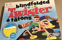 Front of the boxed Blindfolded Twister game showing the title, graphics, and tactile spinner.