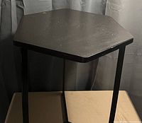 Front angle view of hexagon accent table showing wooden top and metal leg frame