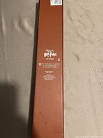 Brown rectangular box with silver Harry Potter Wizarding World branding and text on top.
