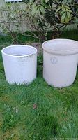 Two stoneware items on grass: 6 gallon crock and ceramic planter