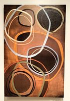 Front view of large abstract print on stretched canvas with overlapping circular shapes in various earth tones.