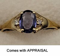 Front view of ring on velvet background showing oval Ceylon blue sapphire and two side diamonds