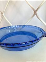 Side view of cobalt blue Pyrex deep dish pie plate showing crimped edge and handle
