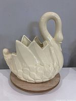 Side view of ceramic swan planter showing textured feather detail and curved neck