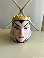 Front view of Evil Queen face coffee mug showing detailed facial features and golden crown.